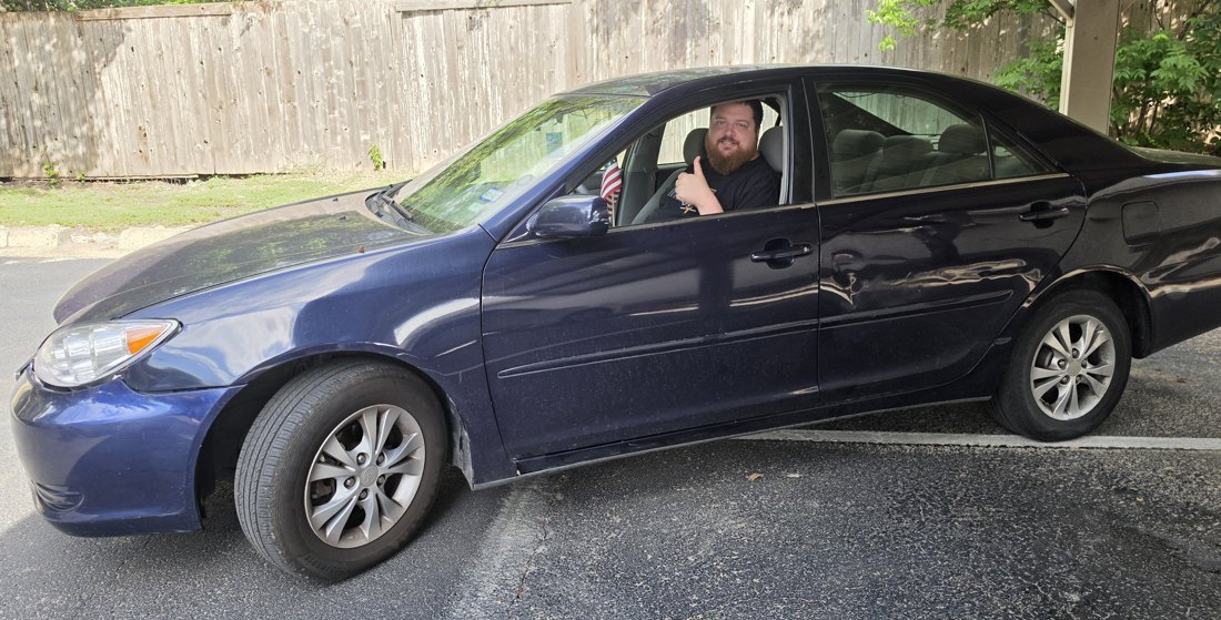 Jonathan giving a thumbs up from his Camry